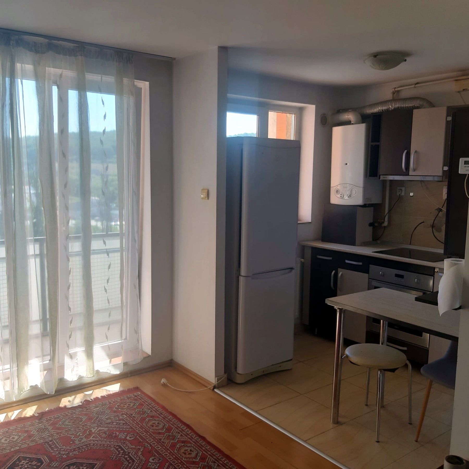 Bucătăria spre balcon, cu frigiderul și zona de gătit